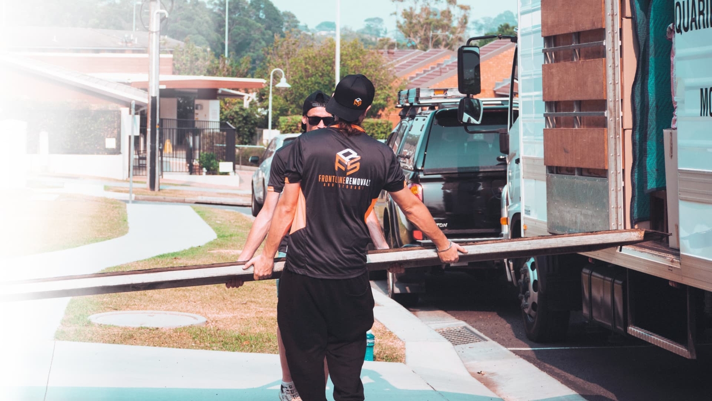 Frontline removalist crew loading materials in trailer truck